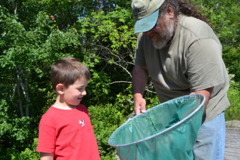 Bailey Bowdwn showing fish in a net to a child